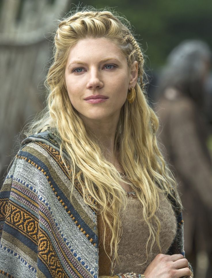 a picture of the actress Katheryn Winnick in her role in the TV series Viking, the woman is blond with her hair braided, she is wearing old nordic clothing and has a small smile